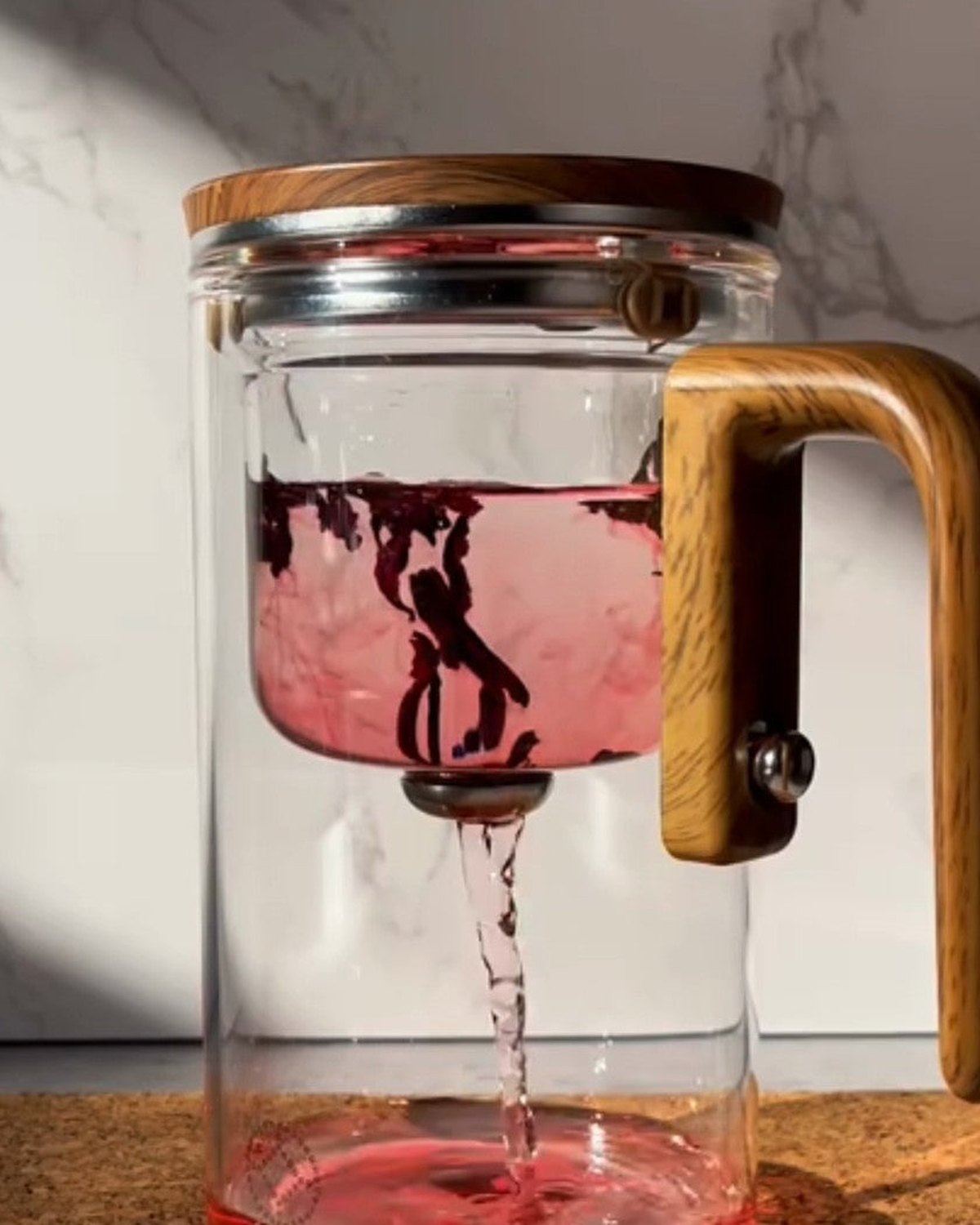 Brühkammer aus Glas mit Blättern – der Tee fällt durch den Edelstahlfilter