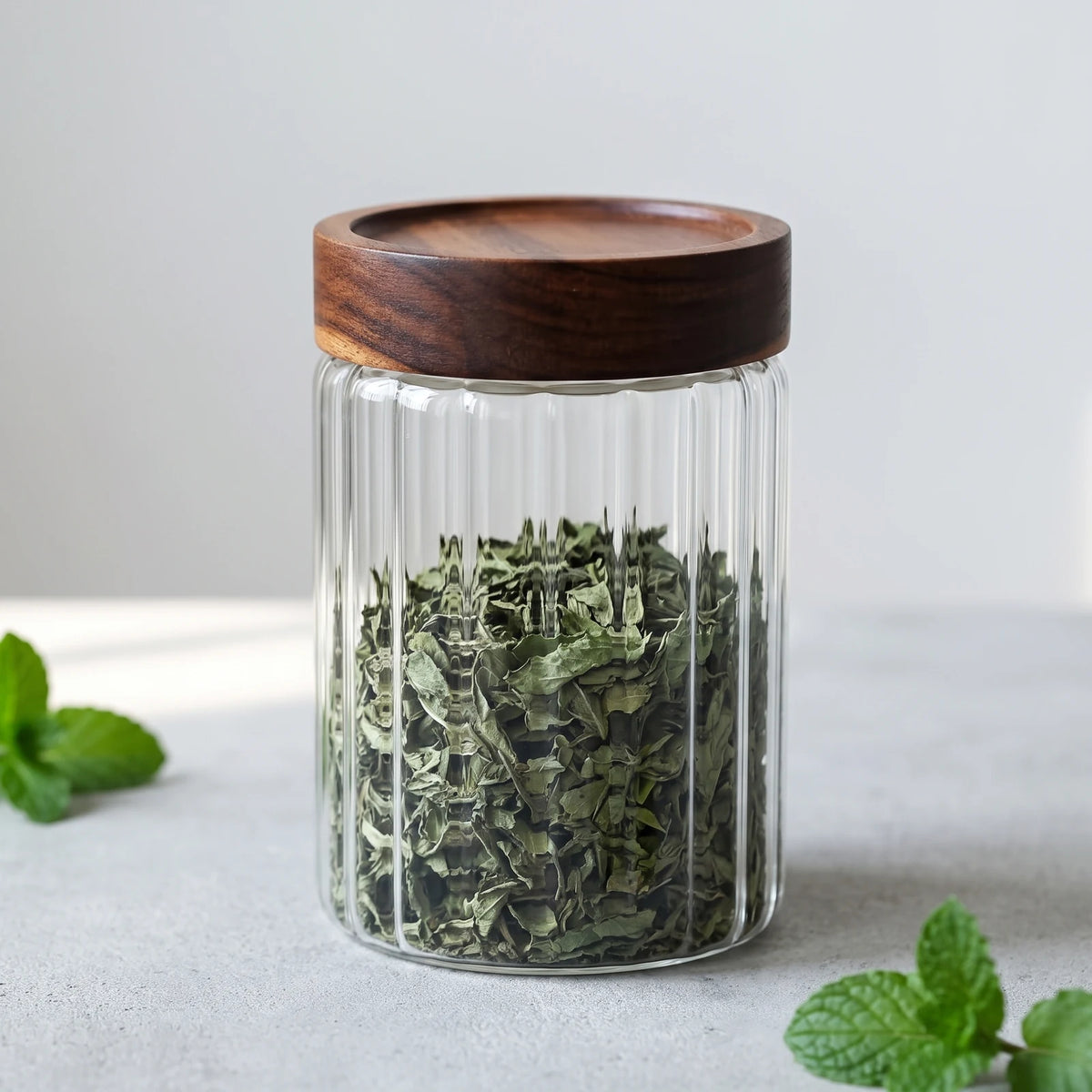 Glas-Teedose 500 ml aus geriffeltem Glas mit dunklem Holzdeckel, gefüllt mit Pfefferminze